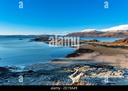 SCOTLAND WEST COAST HIGHLANDS KINTAIL SANDAIG BAY ISLANDS BEACH EMBOUCHURE DE LA RIVIÈRE ET MONTAGNES ENNEIGÉES DE SKYE EN HIVER Banque D'Images