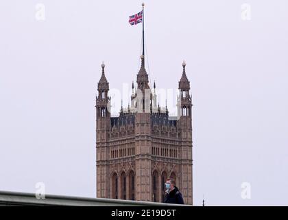 Un homme masqué traverse le pont de Westminster le matin Du 5 janvier 2021 comme le verrouillage national prend effet Banque D'Images