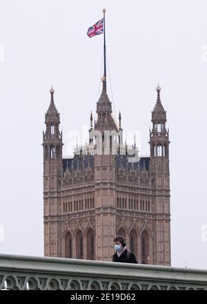 Un homme masqué traverse le pont de Westminster le matin Du 5 janvier 2021 comme le verrouillage national prend effet Banque D'Images