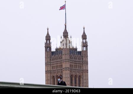 Un homme masqué traverse le pont de Westminster le matin Du 5 janvier 2021 comme le verrouillage national prend effet Banque D'Images