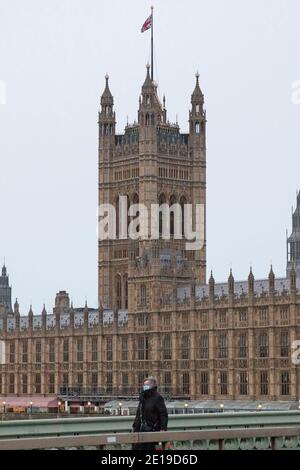 Un homme masqué traverse le pont de Westminster le matin Du 5 janvier 2021 comme le verrouillage national prend effet Banque D'Images