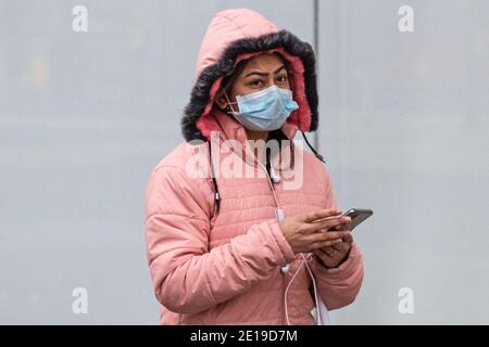 Une femme masquée marche à travers Oxford Street dans le centre de Londres Le matin du 5 janvier 2021 comme Le verrouillage national entre en vigueur Banque D'Images