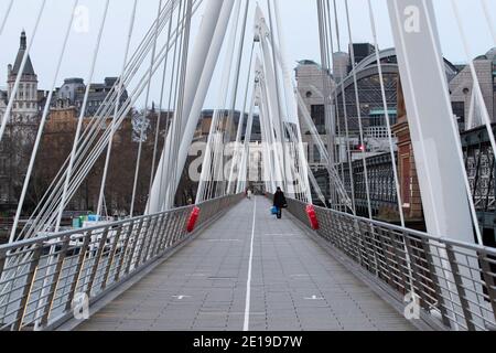 Un homme masqué traverse le Golden Jubilee Bridge dans le centre Londres le matin du 5 janvier 2021 Comme le verrouillage national prend effet Banque D'Images