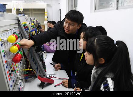 (210105) -- CHONGQING, le 5 janvier 2021 (Xinhua) -- Liang Pan enseigne des étudiants au Chongqing Technician College of Railway Transportation, dans le sud-ouest de la Chine, Chongqing, le 30 décembre 2020. Liang Pan, qui a échoué à l'examen d'entrée au lycée, est maintenant enseignant au Chongqing Technician College of Railway Transportation. D'un étudiant de l'école professionnelle secondaire, d'un profane en électronique à un expert et un champion du monde, il a fallu 6 ans à Liang Pan pour réaliser le rêve. Les expériences de travail à un très jeune âge ont fait de Liang Pan l'importance de maîtriser une compétence et de chérir l'o Banque D'Images