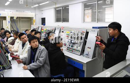 (210105) -- CHONGQING, le 5 janvier 2021 (Xinhua) -- Liang Pan enseigne des étudiants au Chongqing Technician College of Railway Transportation, dans le sud-ouest de la Chine, Chongqing, le 30 décembre 2020. Liang Pan, qui a échoué à l'examen d'entrée au lycée, est maintenant enseignant au Chongqing Technician College of Railway Transportation. D'un étudiant de l'école professionnelle secondaire, d'un profane en électronique à un expert et un champion du monde, il a fallu 6 ans à Liang Pan pour réaliser le rêve. Les expériences de travail à un très jeune âge ont fait de Liang Pan l'importance de maîtriser une compétence et de chérir l'op Banque D'Images