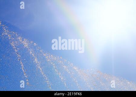 Eau éclaboussant sous le soleil avec l'arc-en-ciel Banque D'Images