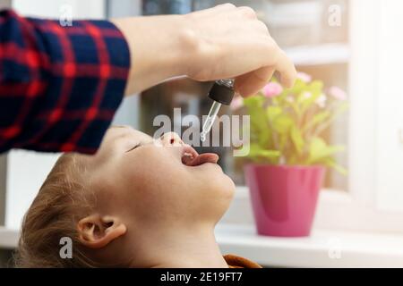 mère donnant des gouttes de vitamine avec compte-gouttes à son enfant. suppléments alimentaires pour les enfants Banque D'Images