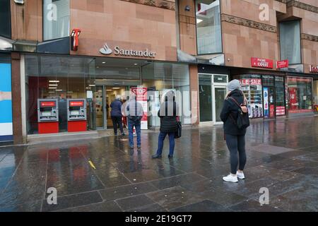 Glasgow, Écosse, Royaume-Uni. 5 janvier 2021. Vue sur un centre-ville très calme de Glasgow alors que l'Écosse se réveille jusqu'au premier jour d'un nouveau confinement national strict annoncé par le gouvernement écossais pour contenir une nouvelle augmentation des infections à Covid-19. Pic ; file d'attente publique à la banque Santander. Iain Masterton/Alay Live News Banque D'Images