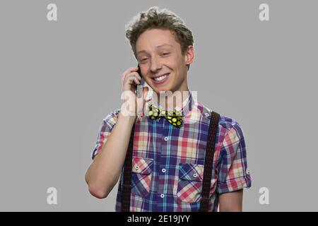 Un jeune garçon souriant parle sur un téléphone portable. Banque D'Images