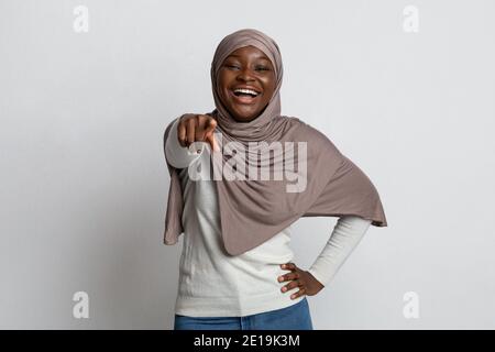 Gotcha. Femme musulmane noire dans hijab pointant le doigt vers la caméra et en riant Banque D'Images