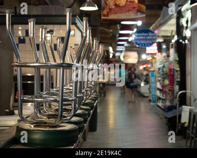 Une série de tabourets de bar empilés sur le comptoir d'un établissement fermé dans le marché du terminal de lecture. Banque D'Images