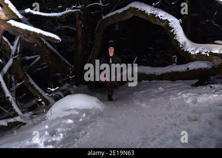Pratiquer le yoga en hiver, dans la forêt la nuit dans la neige. De nouveaux défis avec la neige et le froid vous apprennent à atteindre la mise au point et le contrôle. Banque D'Images