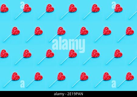 Motif sans couture. Le terrain de la Saint-Valentin. Cœurs de bonbon Lollipop sur fond bleu. Mise à plat Banque D'Images