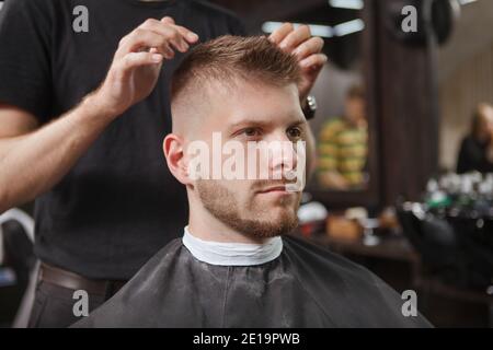 Cheveux barbiers méconnaissables d'un jeune homme barbu Banque D'Images