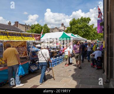 Les amateurs de shopping visitent les stands du marché de Skipton par une journée ensoleillée Banque D'Images