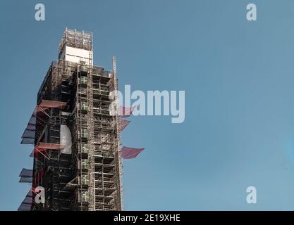 Londres, Angleterre - 19 avril 20 : parement de miroir géométrique angulaire sur un bâtiment moderne à structure répétée sur fond bleu vif. Pas de mise au point, Banque D'Images