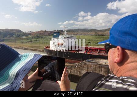 Les visiteurs regardent un navire-citerne passer par les écluses Miraflores du canal de Panama en direction du lac Miraflores. Banque D'Images