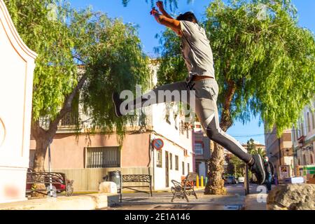 Active Latino jeune homme saut en action. Sport extrême, parkour extérieur gratuit course à pied ou concept de mode de vie sain Banque D'Images