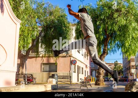Active Latino jeune homme saut en action. Sport extrême, parkour extérieur gratuit course à pied ou concept de mode de vie sain Banque D'Images