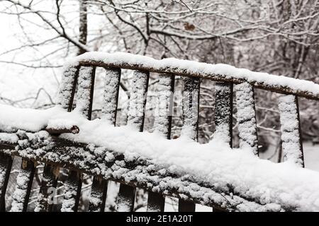 Clôture en bois cassée recouverte de neige fraîche. Neige d'hiver au village Banque D'Images
