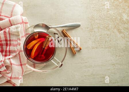 Vin rouge chaud accompagné d'épices et de fruits sur table grise. Boisson chaude traditionnelle pendant les vacances en hiver Banque D'Images