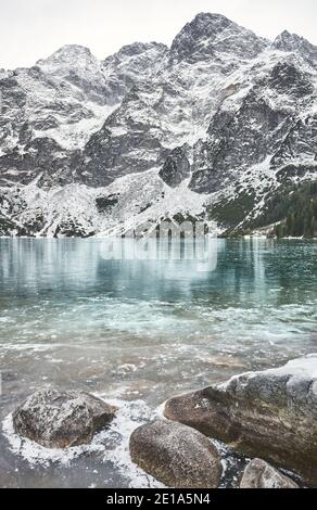 Lac Morskie Oko gelé (œil de la mer) par une journée enneigée dans le parc national de Tatra, Pologne. Banque D'Images