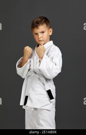 petit garçon dans un kimono de karaté blanc. Un chasseur de karaté prêt à se battre. Banque D'Images