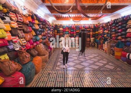 Une jeune femme parcourt une boutique de cuir coloré à Fès, au Maroc, près d'une tannerie traditionnelle Banque D'Images