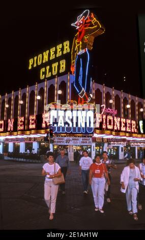 Le Pioneer Club Casino avec panneau de néon de cow-boy agité allumé la nuit sur Fremont Street dans le centre-ville de Las Vegas, Nevada vers les années 1970. Banque D'Images