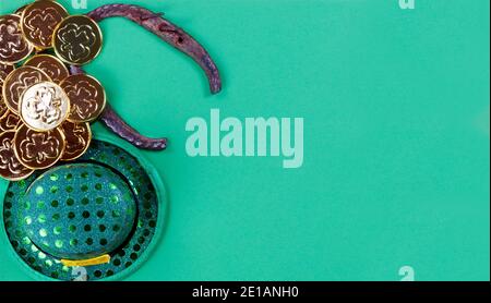 Chapeau d'élan irlandais, chaussure de cheval et pièces d'or sur fond de papier vert avec espace pour les copies Banque D'Images