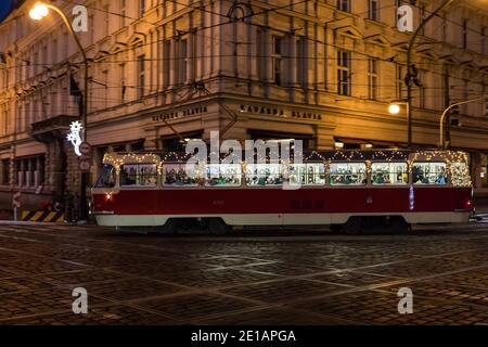 PRAGUE - 30 décembre : tramway T3 avec décoration de Noël et lumières dans la rue entre le Théâtre national et le café Slavia le 30 décembre 2020 à Prag Banque D'Images