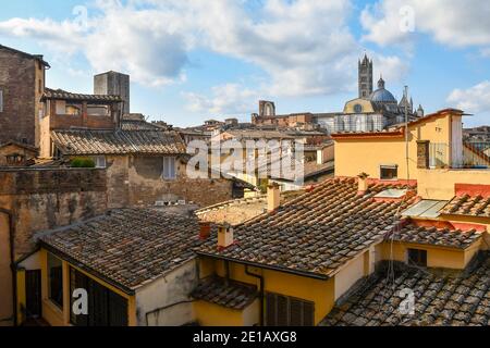 Vue sur les toits du centre historique de Sienne avec la cathédrale en arrière-plan sur le ciel bleu clair, Toscane, Italie Banque D'Images