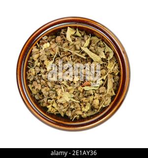 Épice de basilic naturel séché dans un bol en céramique (Ocimum basilicum). Pile d'assaisonnement au basilic séché isolée. Banque D'Images