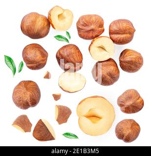 Noisettes entières et écrasées avec des feuilles vertes isolées sur fond blanc. Présentation créative des aliments. Répétition avec des écrous brumels Banque D'Images