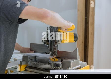 Construction à la maison découpe des moulures en bois avec scie circulaire Banque D'Images