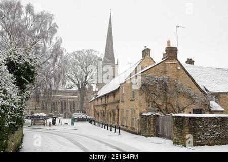 Les grandes Almshres et l'église Saint-Jean-Baptiste le long de la voie de l'église dans la neige de décembre. Burford, Cotswolds, Oxfordshire, Angleterre Banque D'Images