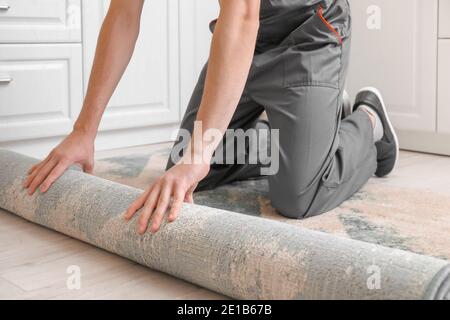 Homme roulant de moquette sur le sol dans la chambre Banque D'Images