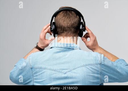 Portrait en gros plan d'un jeune homme joyeux qui apprécie l'écoute musique portant un ensemble jean décontracté Banque D'Images