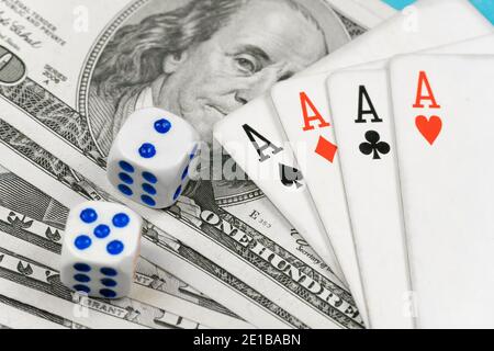 Dés, quatre as se trouvant sur des billets de dollars de gros plan. Concept de jeu de poker Banque D'Images