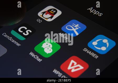 Stafford, Royaume-Uni - janvier 6 2021: Alipay, WeChat, QQ, ShareIt, CamScanner, WPS Office apps vues sur l'écran et le doigt flou sur le dessus de la TH Banque D'Images