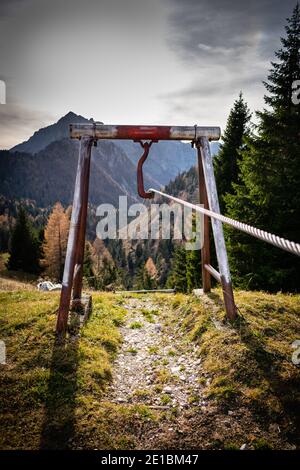 Panorama avec ciel nuageux, montagnes et pentes bordées d'arbres. Au premier plan, un câblage. Cesiomaggiore, Belluno, Italie Banque D'Images