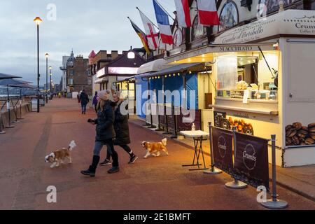 Portobello, Écosse, Royaume-Uni. 6 janvier 2021. Les membres du public ont vu tôt un lever de soleil spectaculaire sur la plage de Portobello. La plage est encore populaire avec les nageurs en eau libre et les randonneurs de chien pendant le verrouillage. Le public maintenait généralement la distanciation sociale et l'exercice en plein air est autorisé en vertu des règles strictes de verrouillage national. Pic; UN café a ouvert tôt et fait du commerce rapide avec les membres du public en profitant du lever de soleil tranquille sur la promenade. Iain Masterton/Alay Live News Banque D'Images