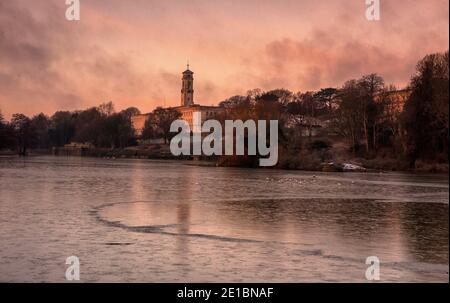 Lever du soleil tôt le matin lumière au-dessus d'un lac gelé à Highfields University Park, Nottingham Notinghamshire Angleterre Royaume-Uni Banque D'Images