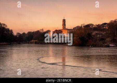 Lever du soleil tôt le matin lumière au-dessus d'un lac gelé à Highfields University Park, Nottingham Notinghamshire Angleterre Royaume-Uni Banque D'Images