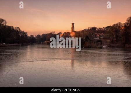 Lever du soleil tôt le matin lumière au-dessus d'un lac gelé à Highfields University Park, Nottingham Notinghamshire Angleterre Royaume-Uni Banque D'Images