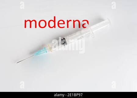 Seringue et signe moderna sur fond blanc, Danemark, 19 décembre 2020 Banque D'Images