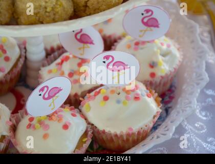 Gros plan de petits gâteaux faits maison avec des bâtons de flamants roses sur une assiette, concept de fête, bonbons pour la fête d'anniversaire, attention sélective Banque D'Images