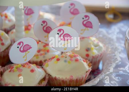 Gros plan de petits gâteaux faits maison avec des bâtons de flamants roses sur une assiette, concept de fête, bonbons pour la fête d'anniversaire, attention sélective Banque D'Images