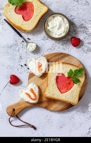 Petit-déjeuner pour la Saint-Valentin ou la fête des mères, toast au saumon et au fromage blanc avec l'inscription Je t'aime. Plan d'étapage avec vue de dessus. Banque D'Images