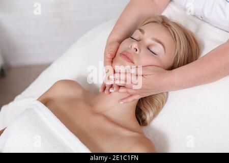 Vue de dessus de près d'une belle femme appréciant le visage massage Banque D'Images